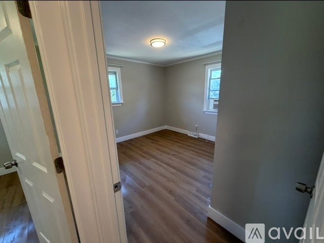 A room with wooden flooring and a white door.