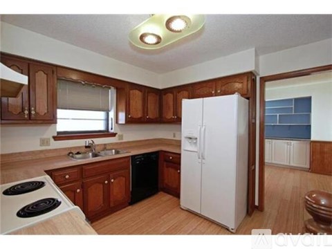 A kitchen with wooden cabinets and a white fridge.