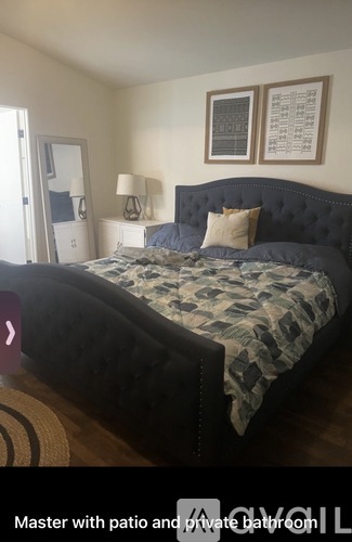 A bedroom with a large bed and a patio.