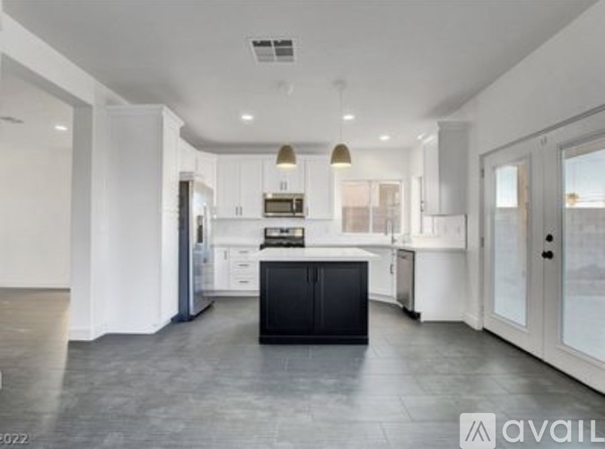 A modern kitchen with a black island in the middle.