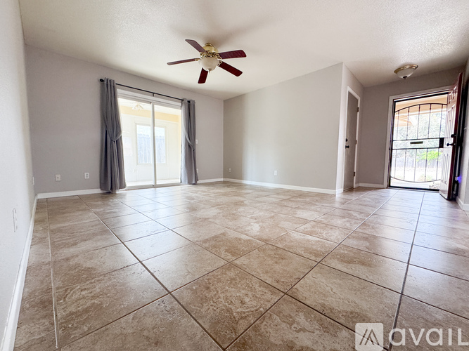 A spacious room with a ceiling fan and tiled flooring.