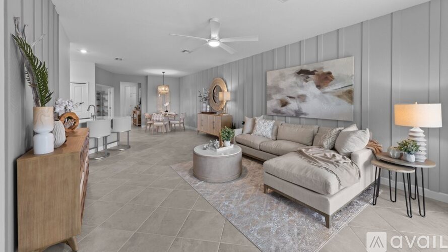 A living room with a grey couch, a wooden cabinet, and a rug.