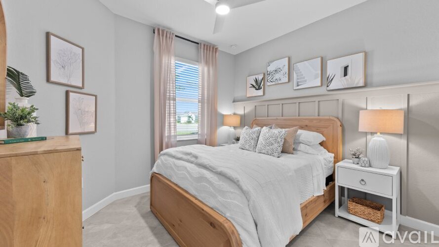 A well-lit bedroom with a large bed and a wooden headboard.