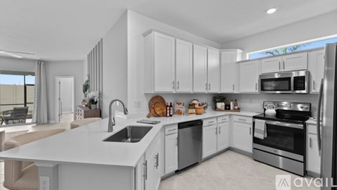 A modern kitchen with white cabinets and stainless steel appliances.