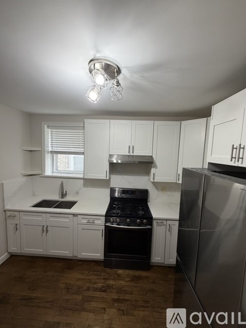 A kitchen with white cabinets and a stainless steel refrigerator.