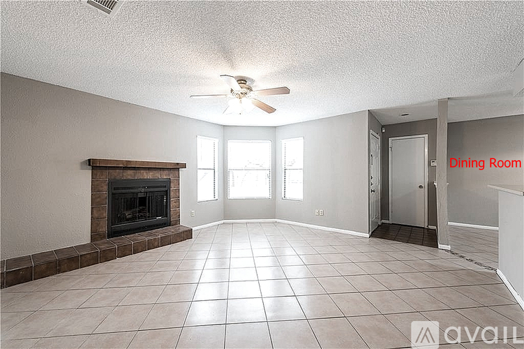 A spacious dining room with a fireplace and tile flooring.