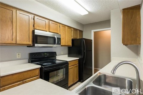 A kitchen with wooden cabinets and a black stove top oven.