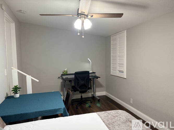 A room with a bed, desk, and chair.