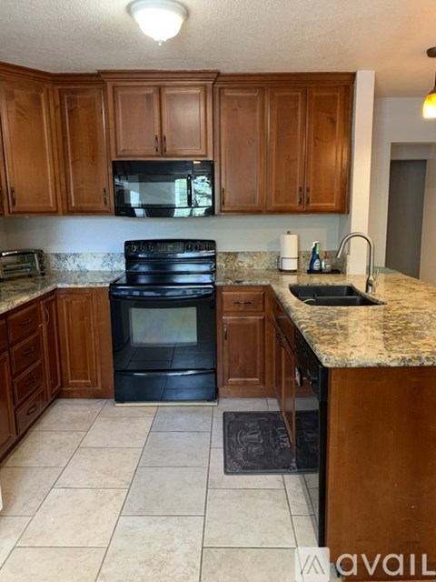 A kitchen with brown cabinets and a black oven.