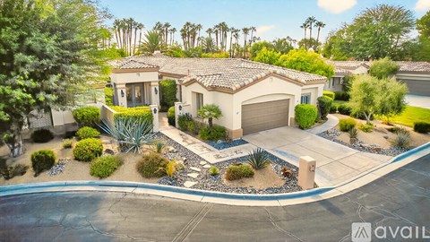 A house with a driveway and a pool in front of it.