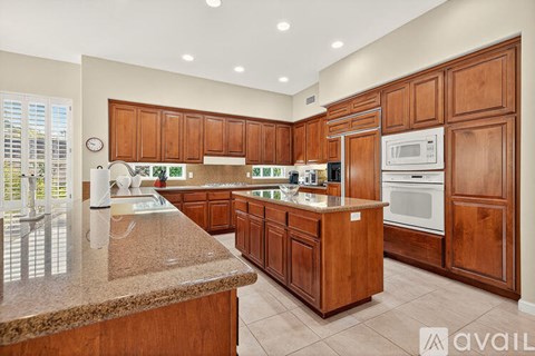 A kitchen with wooden cabinets and a granite countertop.