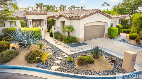 A house with a driveway and landscaping in front.