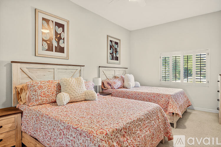 Two twin beds with floral bedspreads in a bedroom.