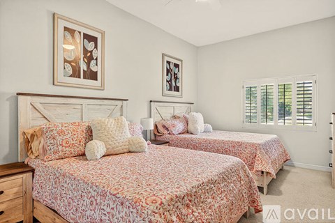 Two twin beds with floral bedspreads in a bedroom.