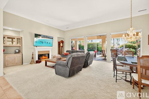 A living room with a grey sofa and a television displaying a beach scene.