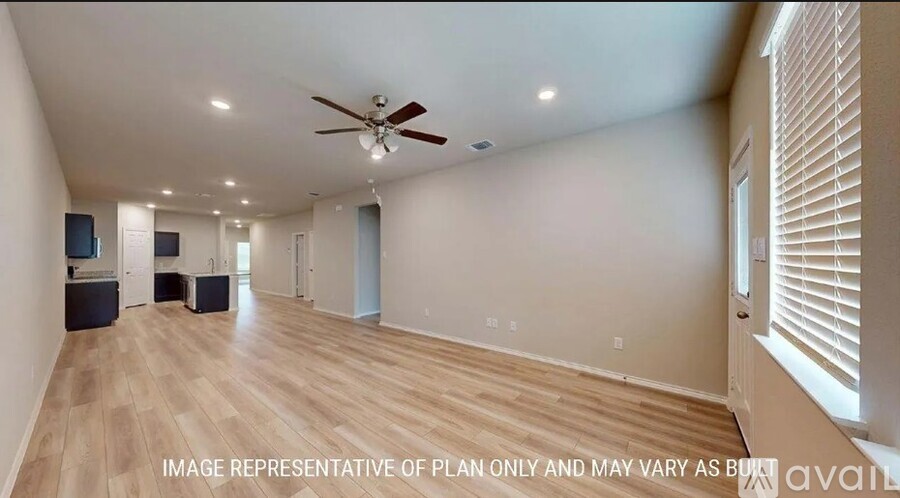 A spacious room with a ceiling fan and wooden flooring.