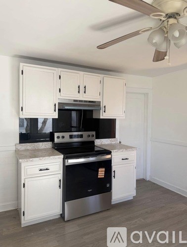 A kitchen with white cabinets and a black stove top oven.