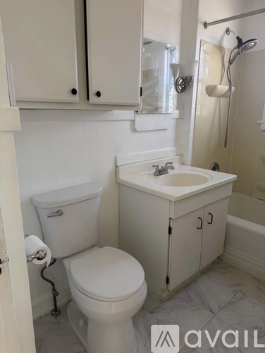 A white toilet with a white sink and a white cabinet.