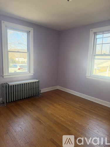 A room with a window and a radiator on the floor.