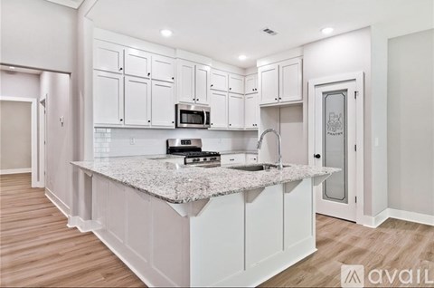A kitchen with white cabinets and a granite countertop.