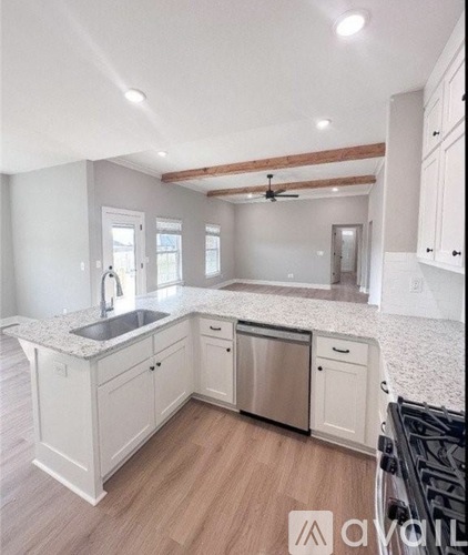 A kitchen with white cabinets and a wooden floor.