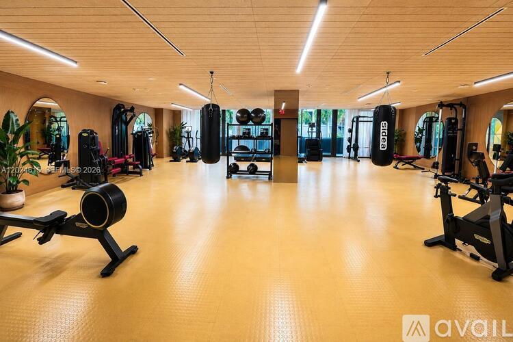 A gym with a variety of equipment including weights and cardio machines.