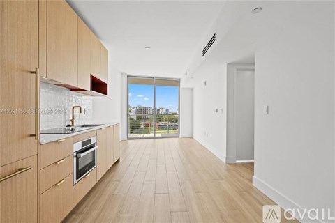A kitchen with wooden cabinets and a view of the city.