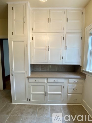 A kitchen with white cabinets and drawers.