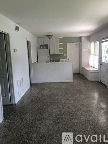 A kitchen area with a white counter and cabinets.