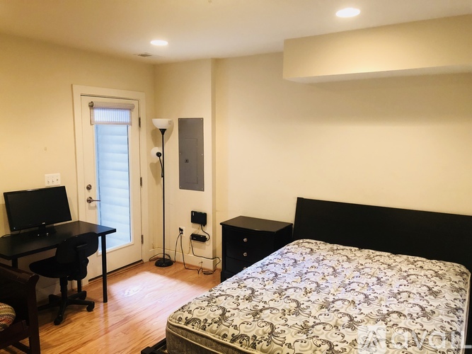A bedroom with a bed, desk, and chair.
