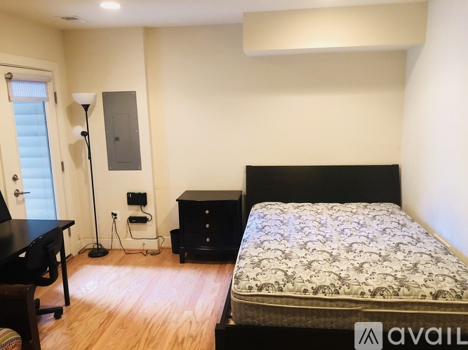 A bedroom with a bed, nightstand, and lamp.