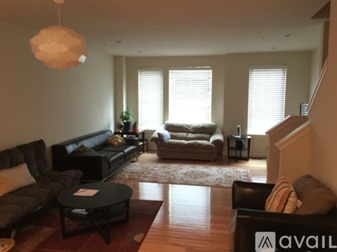 A living room with a black sofa and a coffee table.