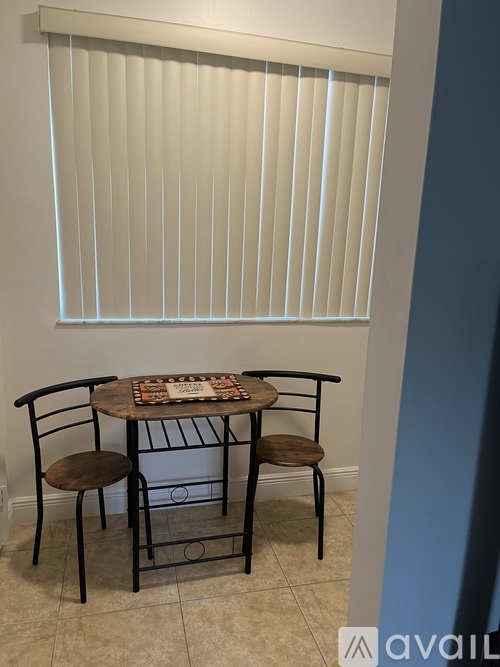 A table with chairs and a pizza on it.
