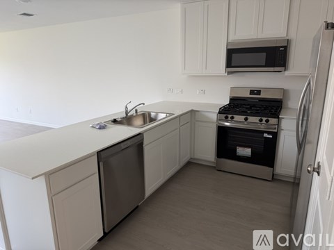 A kitchen with white cabinets and a stainless steel dishwasher.