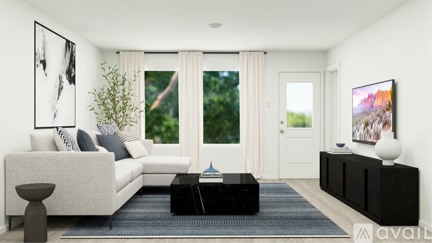 A modern living room with a grey sofa, a black coffee table, and a large window with curtains.