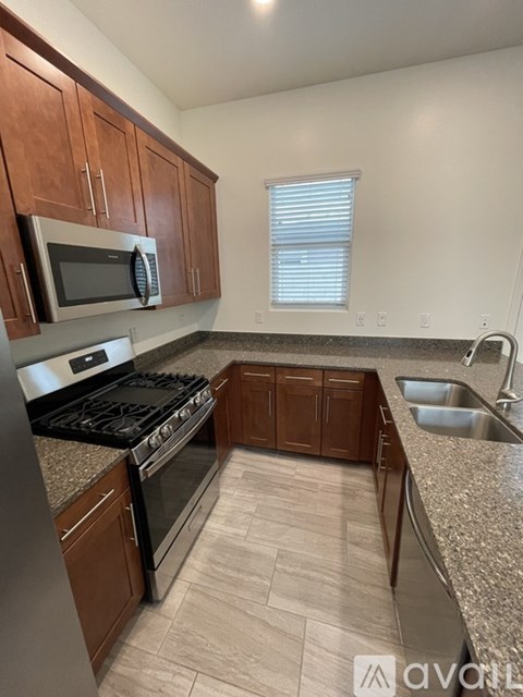 A kitchen with brown cabinets and a stainless steel refrigerator.