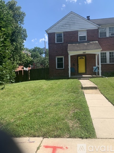 A house with a yellow door and a sign that says "347" on the front.