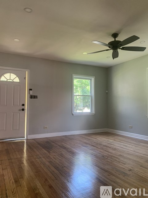 A room with a ceiling fan and a window.