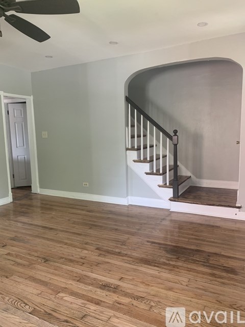 A room with a wooden floor and a staircase.