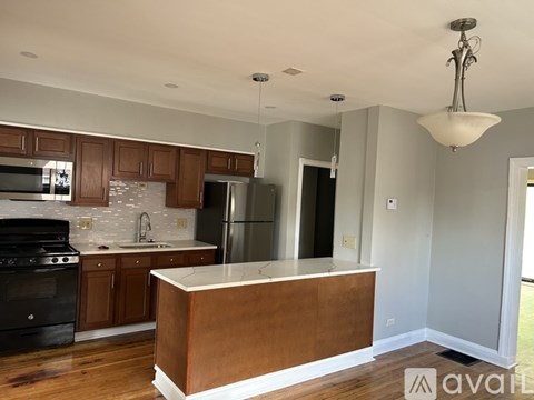 A kitchen with wooden cabinets and a black stove top oven.