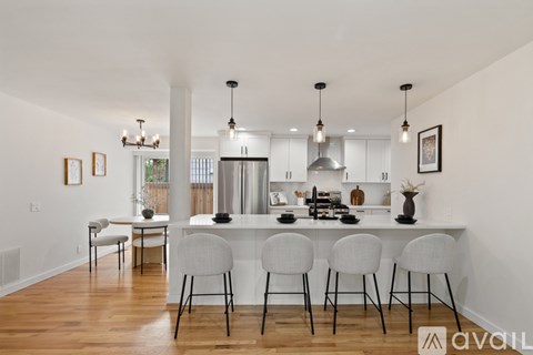 A kitchen with a white counter and chairs.