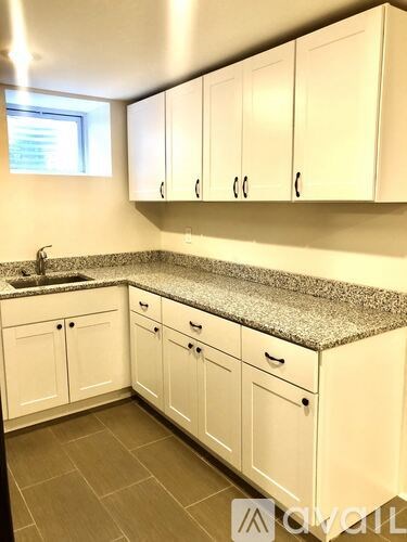 A kitchen with white cabinets and a granite countertop.