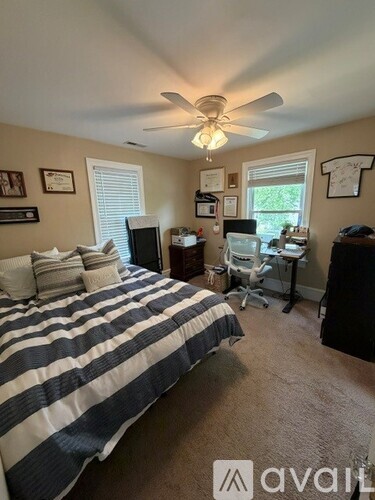 A bedroom with a bed, desk, and chair.