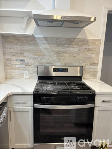 A modern kitchen with a stainless steel oven and a stone backsplash.