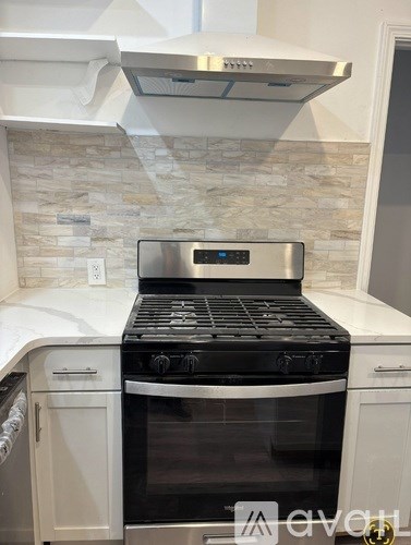 A modern kitchen with a stainless steel oven and a stone backsplash.