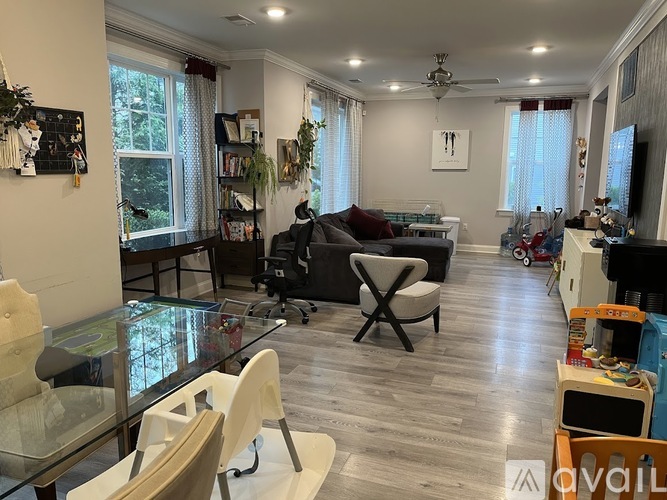 A living room with a glass table and a grey sofa.