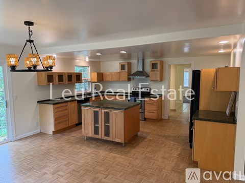 A well-lit kitchen with wooden cabinets and a central island.