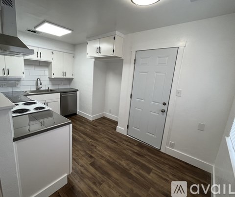 A kitchen with white cabinets and a stove top oven.