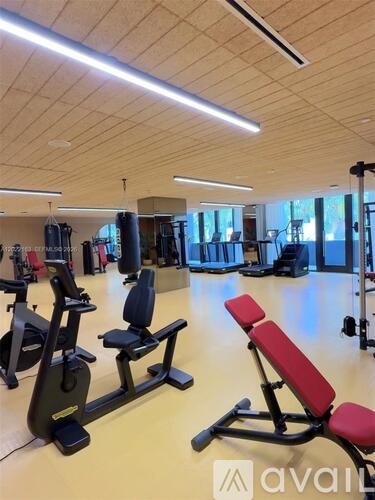 A gym with a variety of equipment including treadmills, weights, and exercise machines.