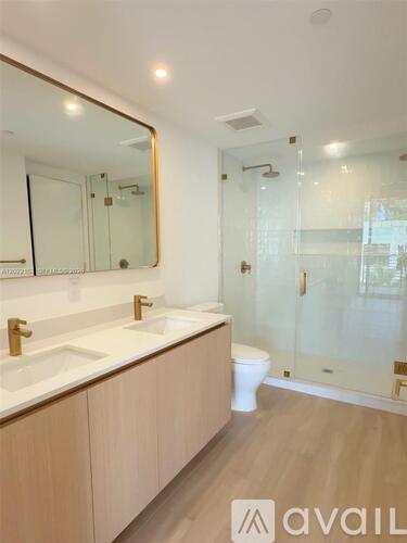 A bathroom with a sink, mirror, toilet and shower.